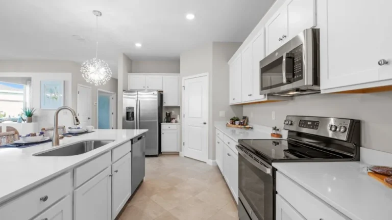 The Trevi kitchen, with the island open to the family room in the Trevi at Valencia Golf & Country Club, Naples FL